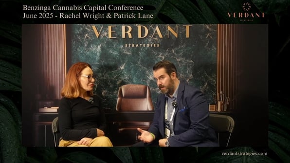 Rachel Wright and Patrick Lane sit across from each other during an interview at the Benzinga Cannabis Capital Conference in June 2025, with a Verdant Strategies backdrop behind them.