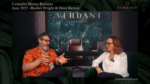 Rachel Wright and Dave Barton sit across from each other during an interview at Cannabis Means Business NYC 2025, with a green marble Verdant Strategies backdrop behind them.
