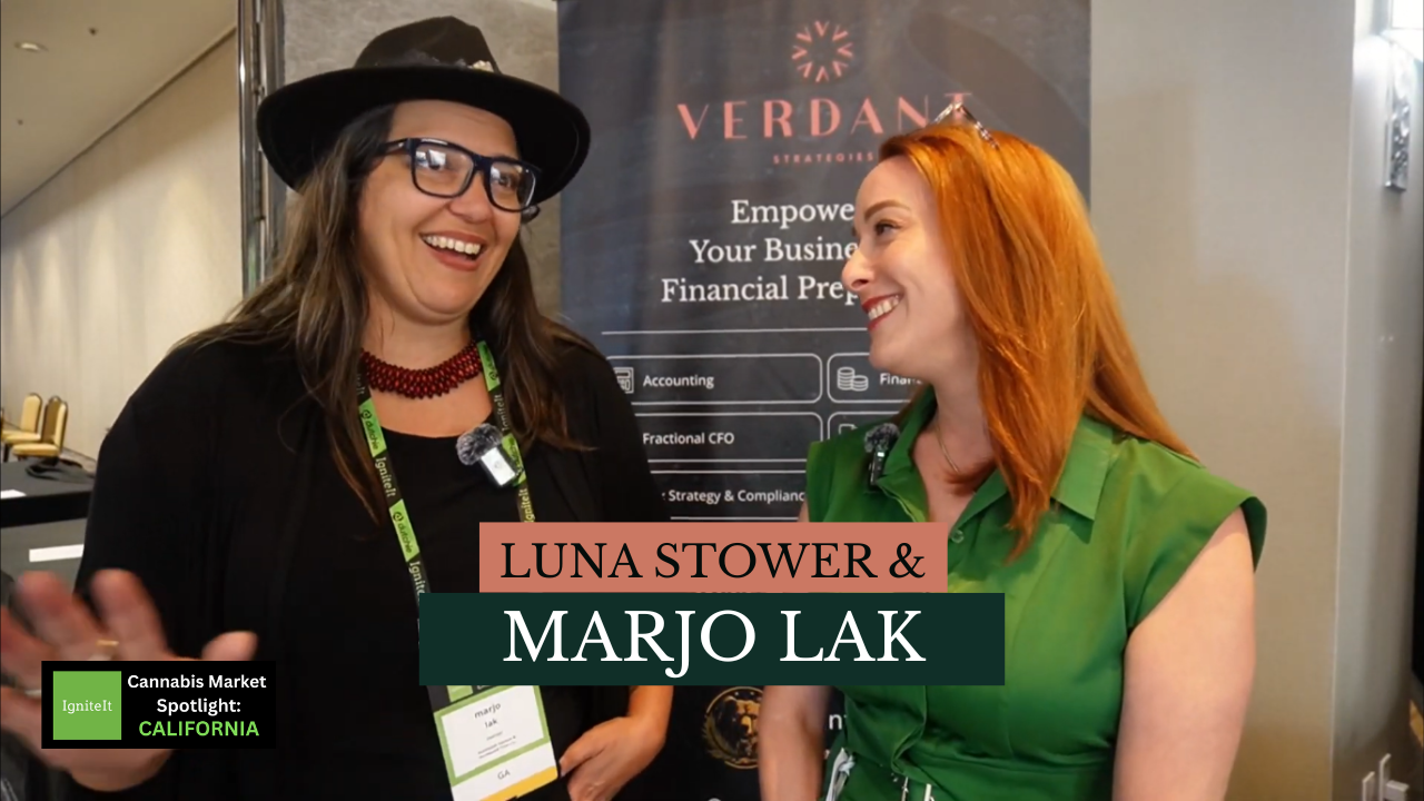 Luna Stower and Marjo Lak smile during an interview at the Verdant Strategies booth at the IgniteIt Cannabis Market Spotlight in California. A Verdant banner reading “Empowering Your Business with Financial Preparedness” is visible in the background.
